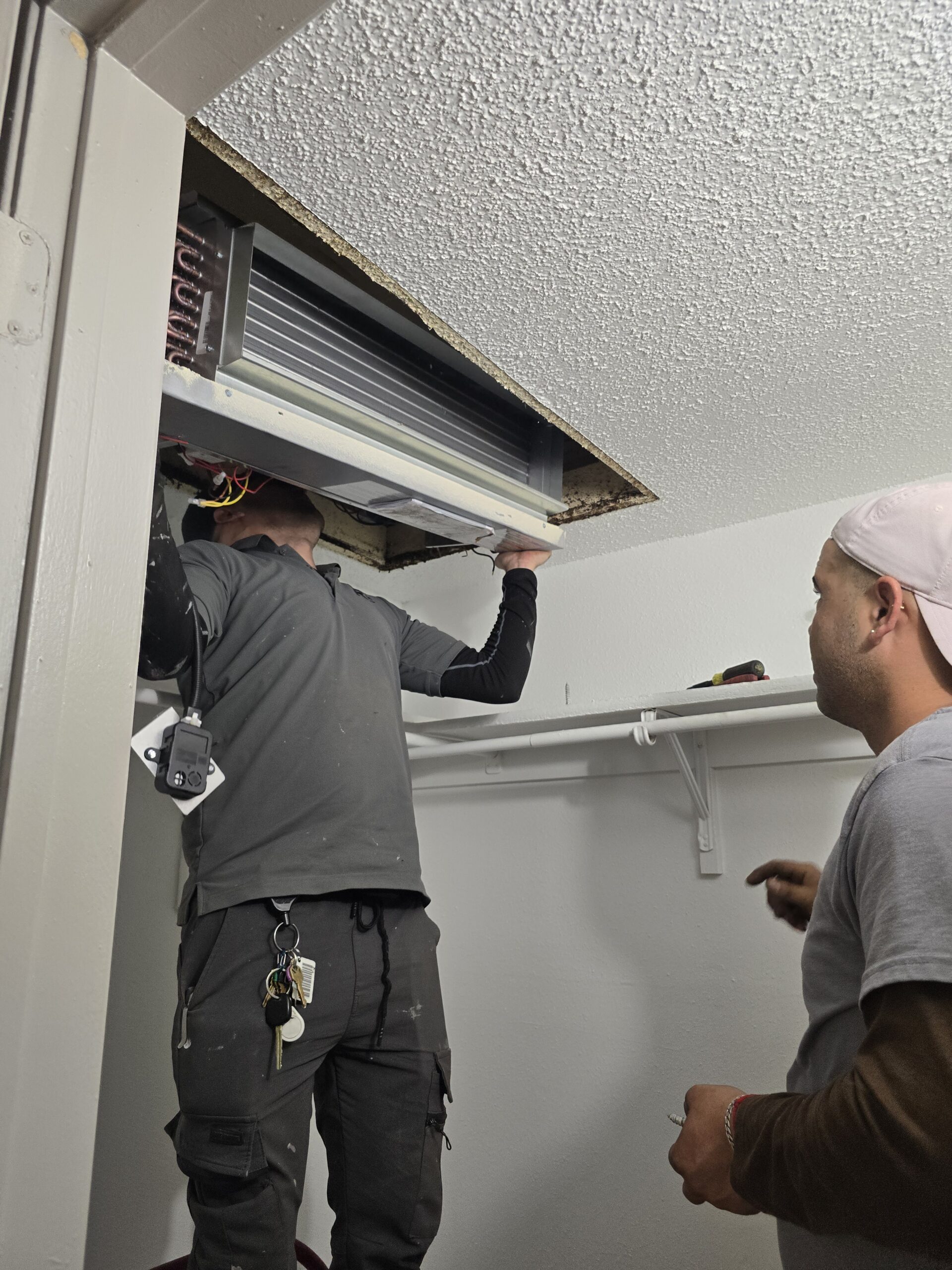 HVAC technician working on air conditioning unit - Torres Pro Services Austin