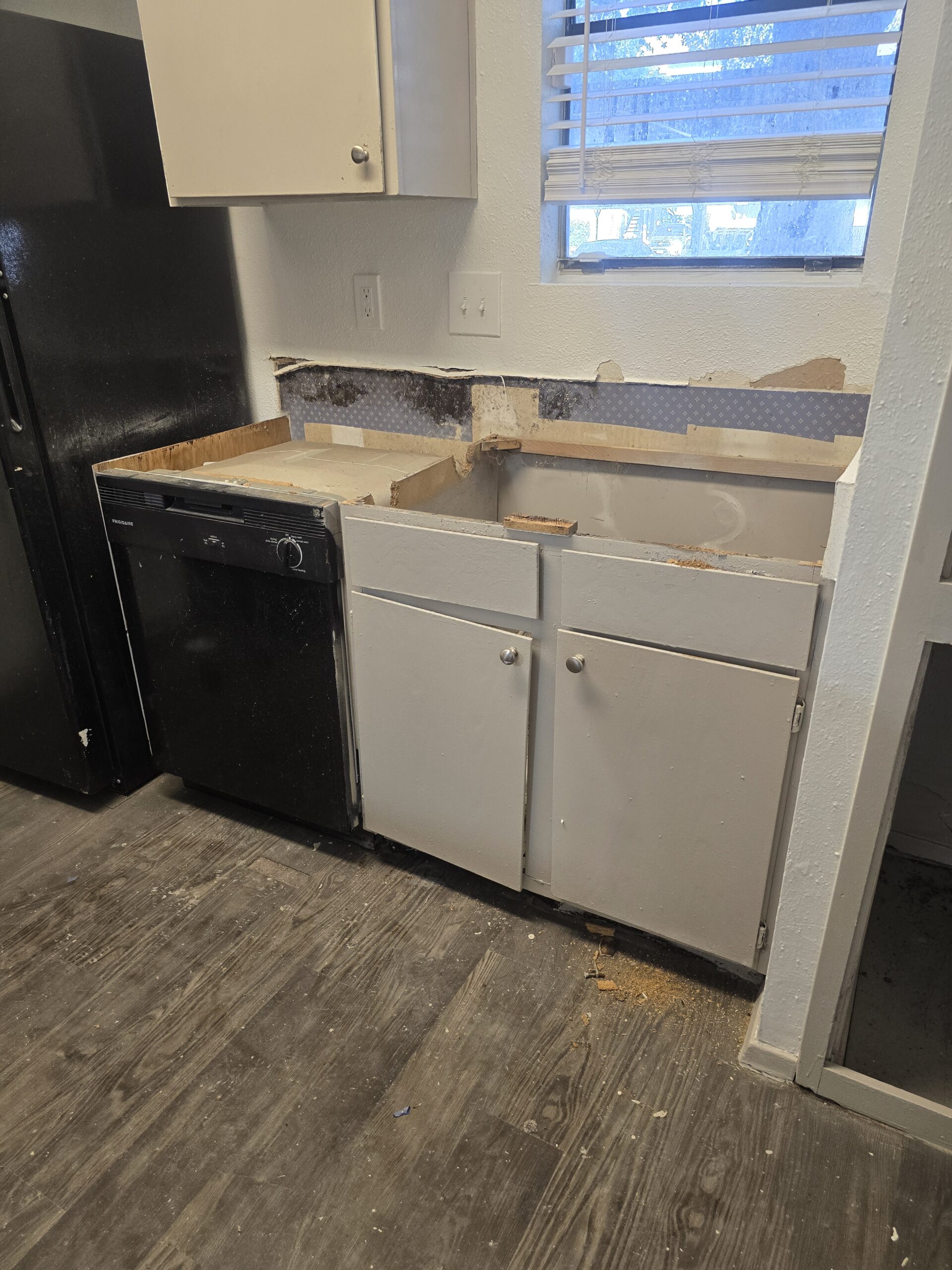 Before: old upper cabinets removed, wall exposed